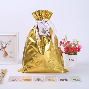 Detail of a golden foil drawstring gift bag with diamond texture and festive gift tags