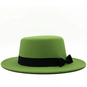 Close-up of vibrant green wool boater hat with black grosgrain ribbon and bow detail