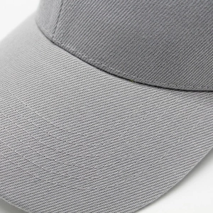 Detailed close-up of grey cotton twill baseball cap with reinforced curved brim stitching