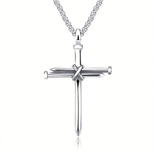 Detailed view of silver cross pendant made of intertwined nails on a polished metal chain