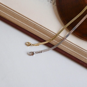 Detail of gold and silver snake bone chain necklaces with secure lobster clasps