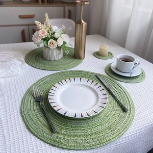 Green Nordic round woven placemats and coasters set in a modern home dining setting
