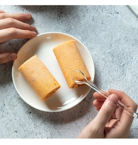 Dettaglio di un cucchiaio in vetro resistente al calore che serve un rotolo di torta