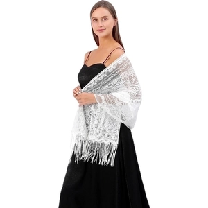 Detail of white hollow lace shawl with floral embroidery and long tassel fringe