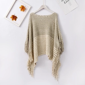 Close-up of chenille knit poncho with vintage striped pattern and long fringe trim details