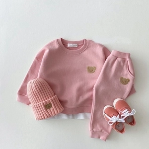 Detailed close-up view of cute bear embroidery on pink cotton baby outfit details.