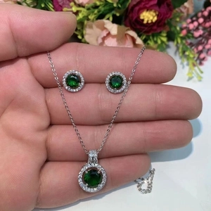 Detailed close-up of emerald green zircon jewelry set with necklace and earrings