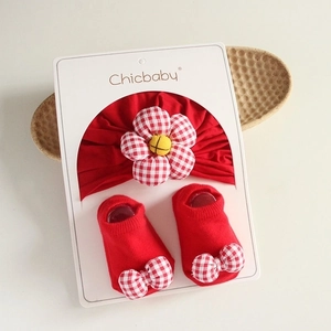 Red baby headband with large flower and matching bow socks in a premium gift box