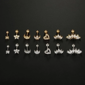 Macro detail of 16G stainless steel studs in gold and silver showing 14 varied designs