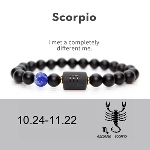 Detail of Scorpio zodiac bracelet featuring matte black agate beads and a blue focal stone