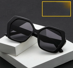 Detail of oversized hexagonal fashion sunglasses with thick black frames on a grey base