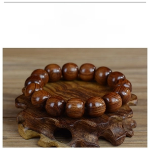 Gros plan de perles en bois Huanghuali polies avec grain naturel sur support en bois