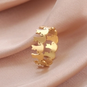 Macro shot of gold stainless steel bird silhouette ring on silk fabric background