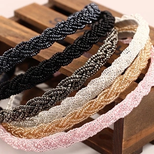 Handmade beaded braided headband set in five elegant colors on a premium wooden stand
