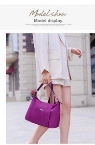 Detail of purple nylon crossbody bag with adjustable strap on a model in a beige suit