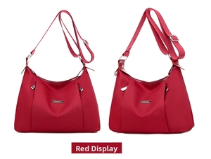 Detail of red water-resistant nylon crossbody bag with adjustable strap and metal trim