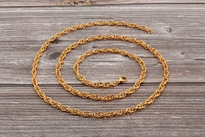 Detailed macro view of a golden twist rope chain with a polished metallic finish
