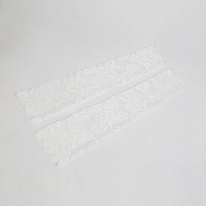 Detail of white lace sun protection arm sleeves with intricate floral crochet patterns