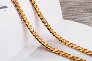 Close-up of golden Cuban link chain belt showing detailed metal craftsmanship and texture