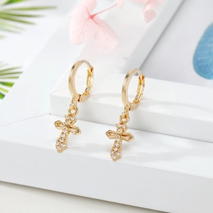 Gold plated cross dangle earrings with micro-paved zircons on white geometric background