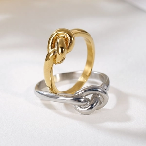 Elegant gold and silver knot rings with high-polish finish on a neutral background