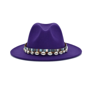 Close-up of purple fedora hat featuring a bohemian shell decorative band and wide brim