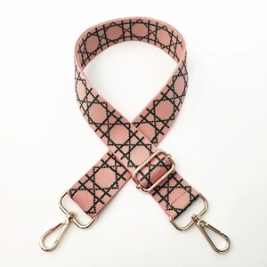 Detail of adjustable wide pink strap with geometric patterns and gold metal buckles