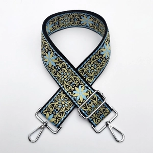 Close-up of thick ethnic jacquard strap with blue gold embroidery and silver metal clasps