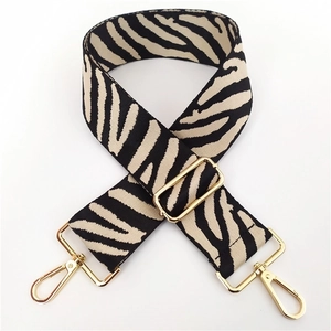 Detail of adjustable zebra pattern woven strap with premium golden metal hooks
