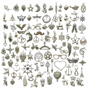 Detailed assortment of antique silver alloy charms including animals and diverse shapes