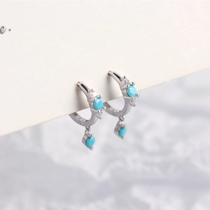 Close-up of S925 sterling silver hoop earrings with turquoise stones and cubic zirconia