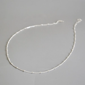 Vista macro della collana a catena con perline d'argento e sfere metalliche lucide
