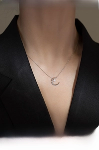 Detail of 925 sterling silver moon and star necklace pendant with sparkling cubic zirconia