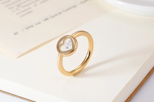 Macro shot of heart-shaped gold ring with floating diamonds on blurry book background