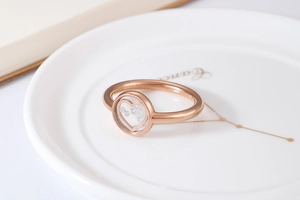 Close-up of rose gold ring featuring a hollow heart design with sparkling small diamonds