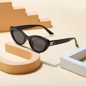 Fashionable black cat-eye sunglasses with luxury metal B-logo and dark gray lenses