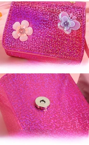 Detail of pink sequin kids purse showing floral decorations and magnetic metal snap closure