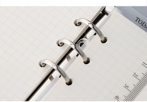 Detail van 6-gaats metalen ringen met ruitjespapier en transparante bladwijzerliniaal