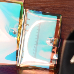 A5 laser transparent loose-leaf notebook binder with rainbow holographic finish on wood desk
