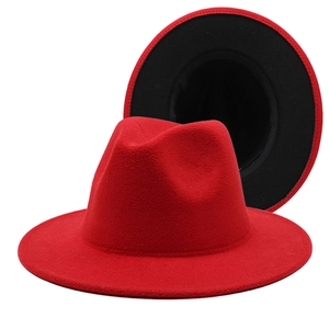 Detailed view of bicolor fedora hat with bright red wool felt exterior and black interior