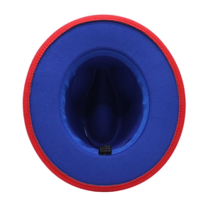 Macro view of bicolor wool fedora hat showing red exterior and cobalt blue interior