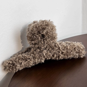 Close-up of soft brown plush shark hair claw clip showing fluffy teddy texture details