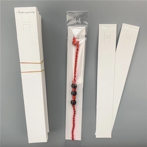 Red braided bracelet with black beads on a white Fashion Jewelry display card