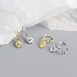 Detail of S925 silver bohemian evil eye hoop earrings with turquoise stones and gold finish
