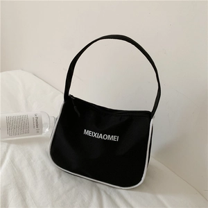 Detail of minimalist nylon shoulder bag with white piping and logo on white surface