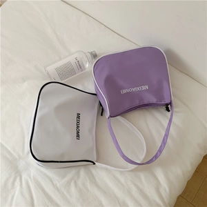 Minimalist nylon underarm bags in lilac and ivory with bold logo prints on white bedding
