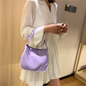 Detail of purple nylon hobo bag with contrast white piping and letter print detail