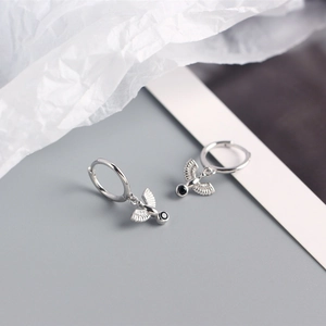 Detail of silver S925 peace dove hoop earrings with black stone and textured wings