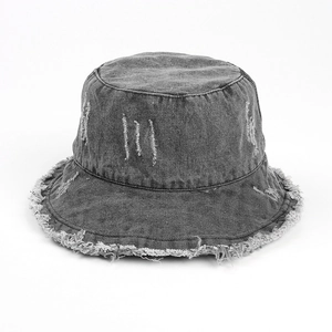 Detail of grey washed denim sun hat featuring frayed edges and vintage distressed textures