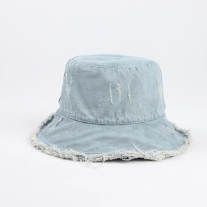 Detail of light blue denim bucket hat featuring frayed edges and vintage distressed texture